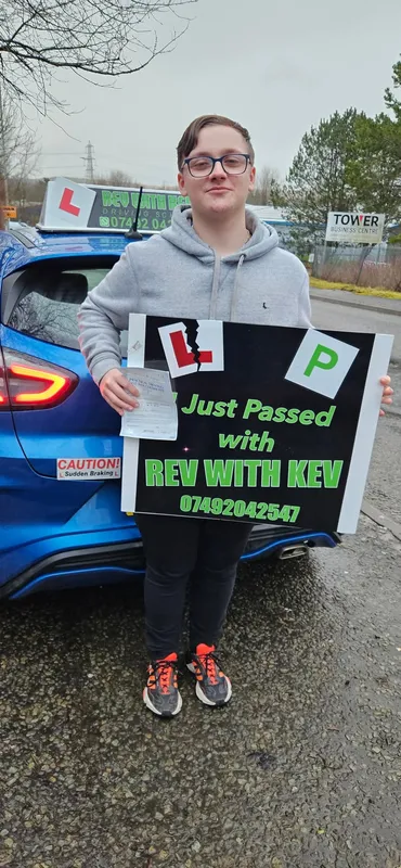 Young student with I Just Passed sign and ripped L-plates at Rev with Kev driving school